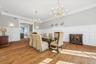 Hardwood flooring, wainscoting, decorative fireplace, crown molding, and wall sconces