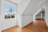 Hardwood flooring, white wall paneling, double-hung window, white trim, recessed lighting