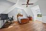 Hardwood flooring, two windows with white trim, recessed lighting, ceiling fan, and wainscoting details