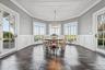Coffered ceiling with a chandelier, wainscoting, multiple large windows, and dark tile flooring