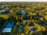 MIDDLE OF PROPERTY AERIAL. BASTBALL COURT AND OUTDOOR ICE SKATE. GUESTHOUSE, CLUBHOUSE, AND SPA/GYM HOUSE