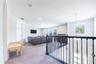 Spacious upstairs loft with a comfortable lounge area and decorative metal railings overlooking the foyer.
