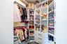 Custom walk-in closet with built-in shelving, drawers, and double hanging rods.