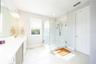 Refined primary bathroom with a frameless glass shower and marble-look tile finishes.