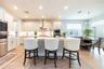 Spacious kitchen island with seating for three, complemented by white cabinetry and a decorative tile backsplash.