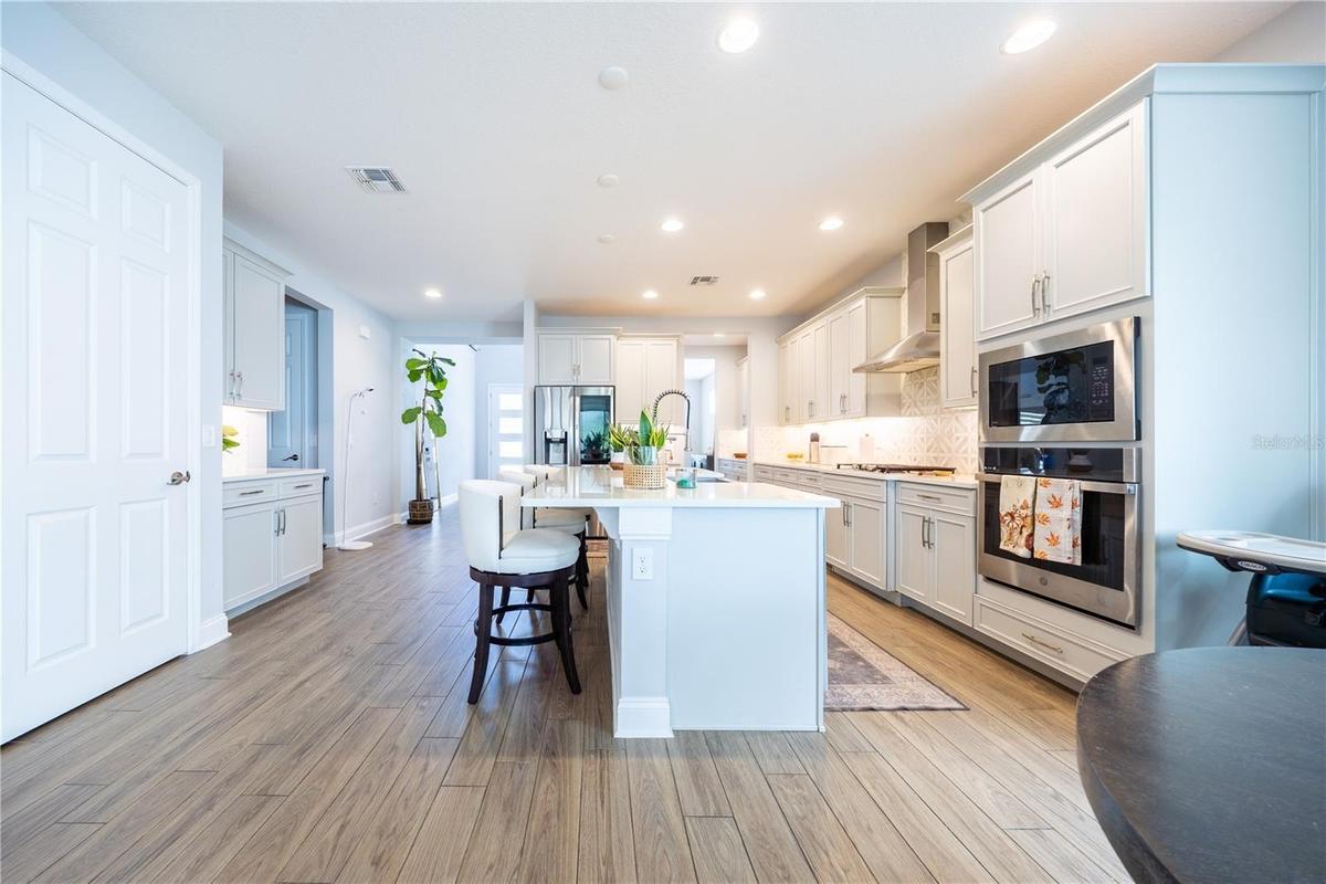 Elegant kitchen with white cabinetry, a spacious island with seating, and stainless steel appliances.