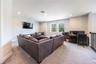 Versatile upstairs loft with spacious seating and a home office area overlooking the trees.