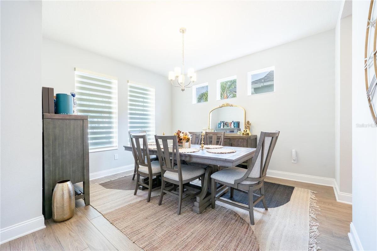 Elegant dining room with abundant natural light and a classic chandelier.
