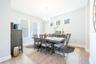 Elegant dining room with abundant natural light and a classic chandelier.