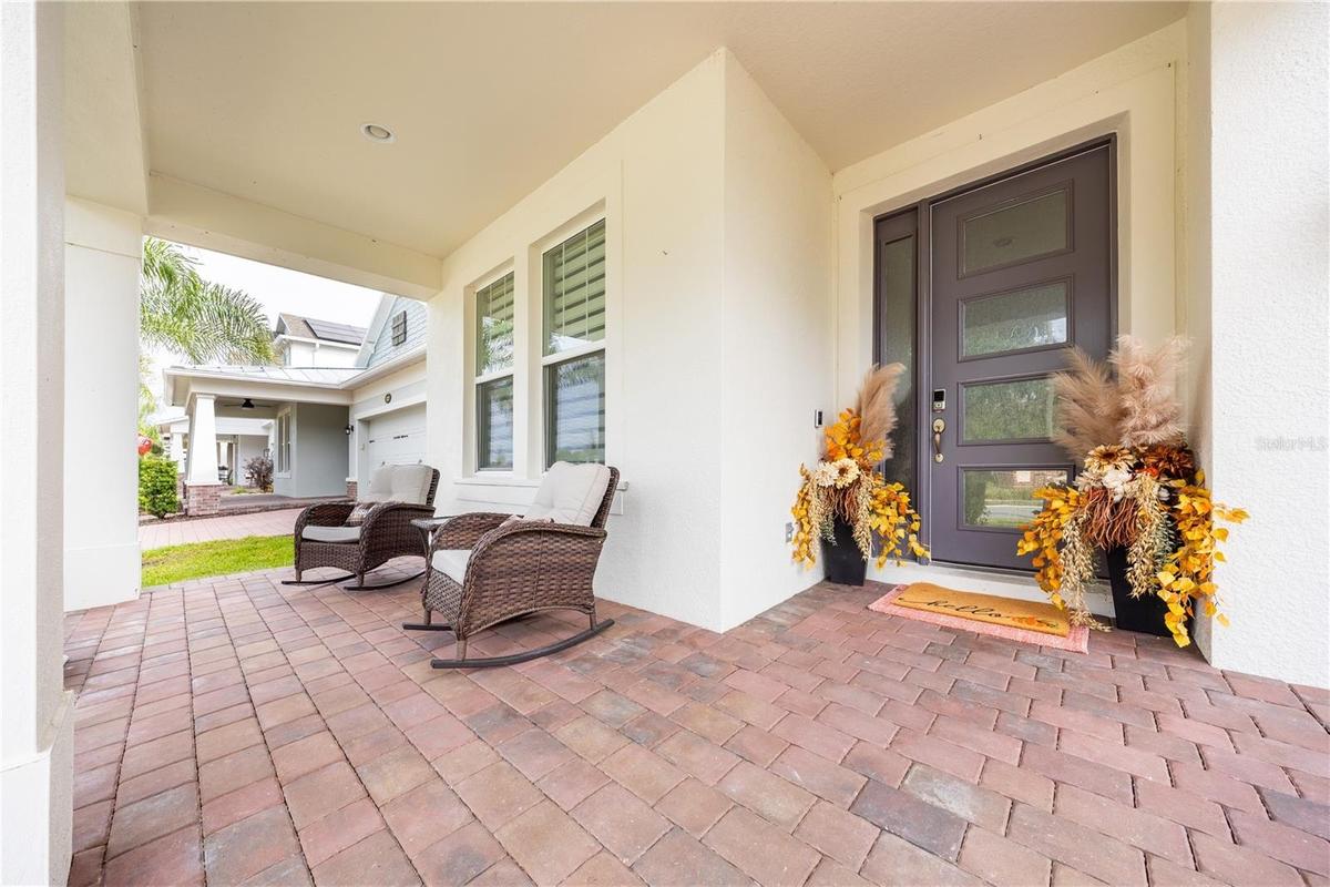 Inviting covered front porch with seating and a stylish entry door.