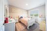 Inviting bedroom with a decorative accent wall, soft carpeting, and views of nature.