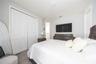 Comfortable bedroom with a spacious closet, soft carpeting, and a refined neutral palette.