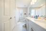 Well-appointed bathroom with a dual-sink vanity, ample storage, and a tub-shower combination.