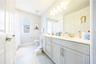Spacious bathroom with a dual-sink vanity, expansive mirror, and ample cabinet storage.