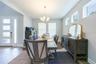 Elegant dining room with high windows and a classic chandelier, just off the foyer.