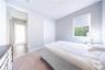 Bedroom with soft neutral tones, carpet flooring, a closet with folding doors, and a window overlooking greenery.