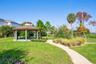 Covered picnic pavilion surrounded by lush landscaping, with a walking path leading toward the lake.