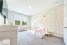 Charming bedroom with a floral accent wall, decorative sconces, and windows with lake views.