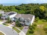 Aerial view showcasing the home’s conservation backdrop, no rear neighbors, and the lake beyond.