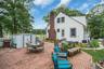 Expansive brick paver patio featuring a white picket fence, and a storage shed
