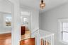 Hallway upstairs, original light fixture, hardwood floors, door to full bath