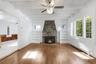 Living room with built in Book Shelves, Floor to Ceiling Stone Fire Place, and Plenty of Natural Light