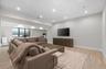 Recessed lighting, light wood-finish flooring, built-in media console, large windows, and a dedicated fitness area