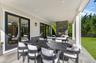 Covered patio with stone flooring, recessed lighting, and a stone-clad outdoor fireplace