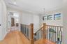 Hardwood flooring, wood newel post, black wrought iron balusters, recessed lighting, and white trim molding