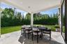 Covered outdoor patio with recessed lighting, large format pavers, and a manicured lawn