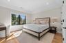 Recessed lighting, wood-finish flooring, and a large window with black framing
