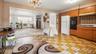 Kitchen with wood cabinetry, built-in double oven, and patterned floor tile