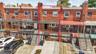 Red brick exterior with multiple windows, a red awning, and an attached front balcony