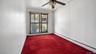 Sliding glass door with vertical blinds, ceiling fan with integrated lighting, and red carpeting