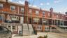 Brick facade with white trim windows and a covered entry