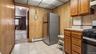 Kitchen with stainless steel refrigerator, tile flooring, wood-finish cabinetry, and a gas range