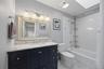 Updated Primary Bathroom (2020) with marble vanity & floor, bathtub and skylight