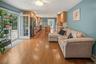 Hardwood flooring throughout, kitchen with stainless steel appliances, light wood cabinetry, and a large island