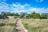 Elevated coastal property featuring complemented by surrounding mature trees and a wooden boardwalk