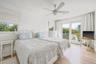 Dual window treatments, ceiling fan, sliding glass door to exterior, and wood-finish flooring