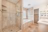 Glass-enclosed shower with tile surround and built-in shelving
