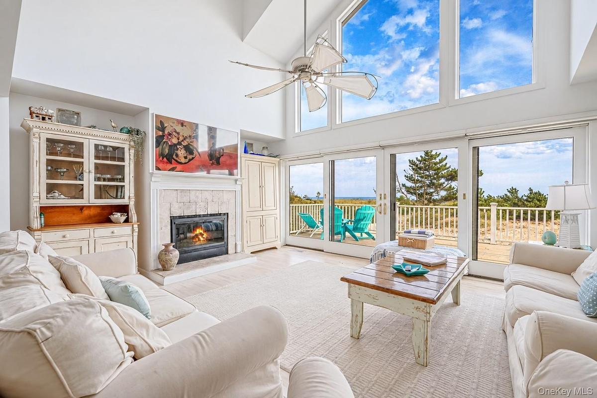Vaulted ceilings, large picture windows, and sliding glass doors open to a deck overlooking the ocean
