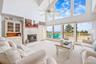 Vaulted ceilings, large picture windows, and sliding glass doors open to a deck overlooking the ocean
