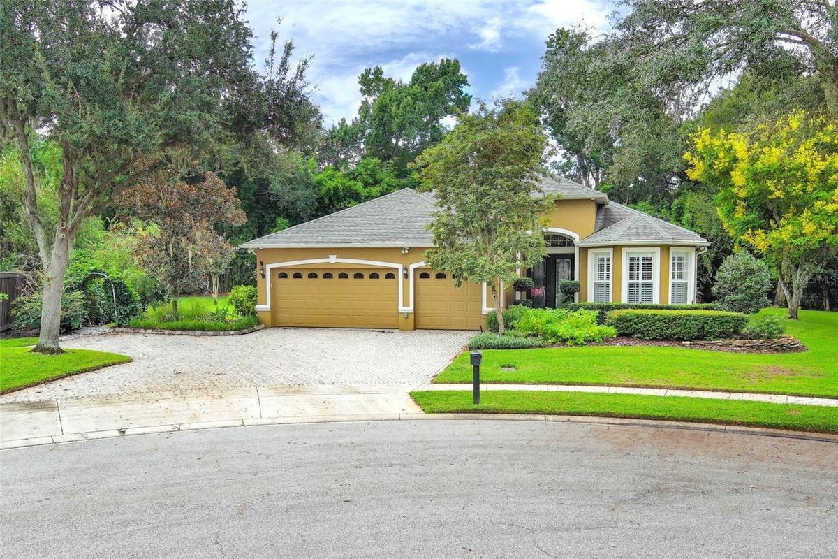 Front elevation with 3 car garage and additional pavered parking pad off to left