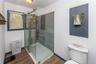 Large walk-in shower with sliding glass shower doors.