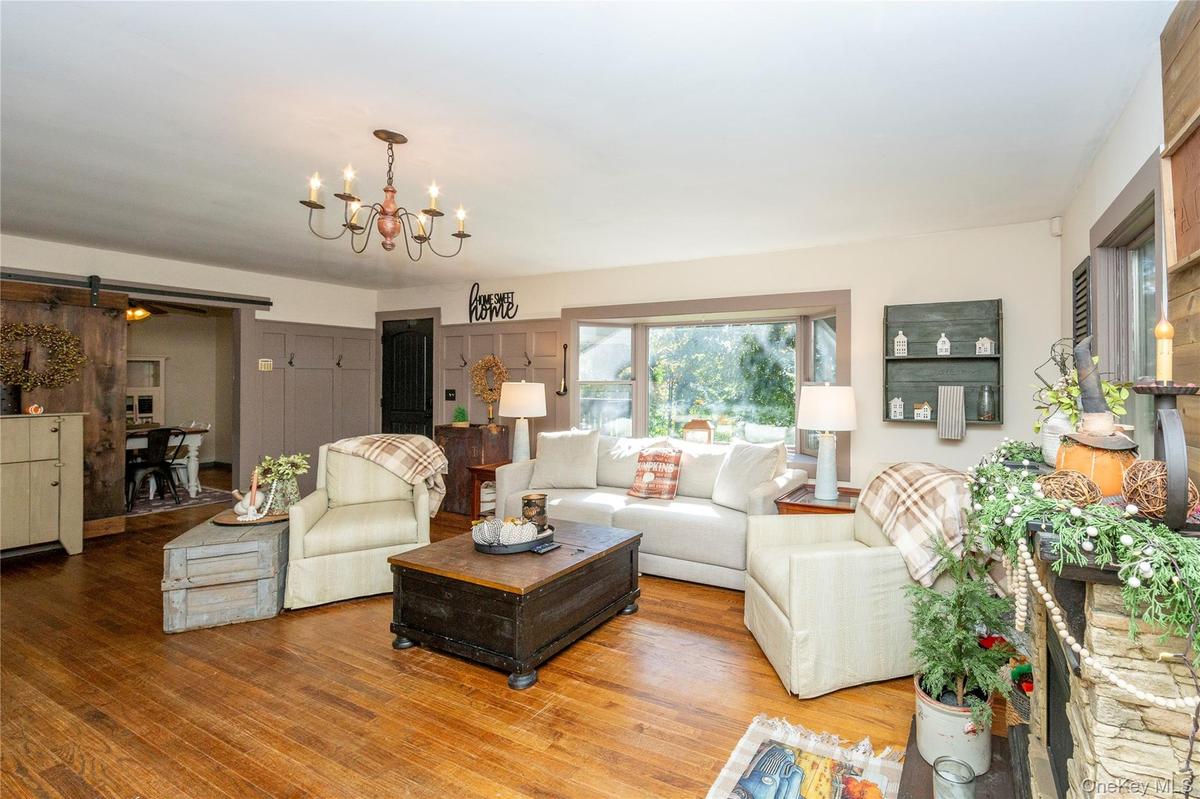 A large bay window,  and a rustic sliding barn door leading to the adjacent dining room.