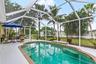 Alternate view of the pool with poolside seating and outdoor dining area.