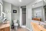 Primary bathroom with vintage clamshell-style sink and shower.