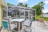 Outdoor dining patio beyond the screened pool enclosure.
