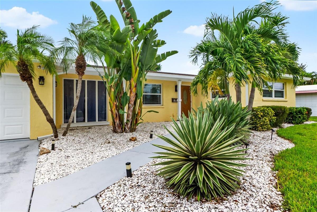 Tropical landscaping frames the front of the home.